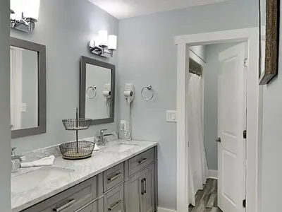 a bathroom with two sinks and two mirrors at Edgewater Villa #2012 in Panama City Beach