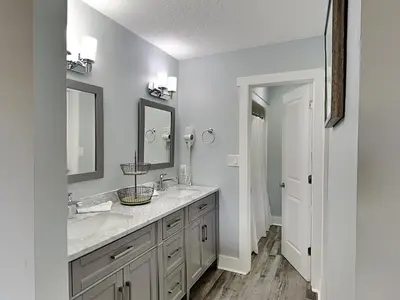 a bathroom with two sinks and two mirrors at Edgewater Villa #2012 in Panama City Beach