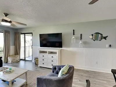 a living room with a couch and a tv at Edgewater Villa #2012 in Panama City Beach
