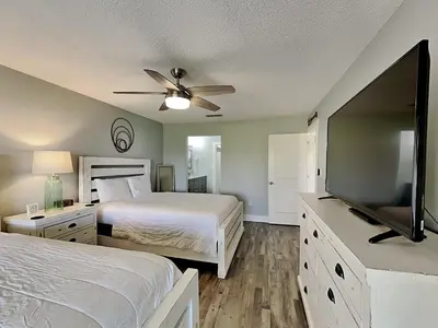 a bedroom with two beds and a flat screen tv at Edgewater Villa #2012 in Panama City Beach