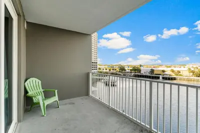 a green chair sitting on a balcony with a view at Laketown Wharf #319 by Nautical Properties in Panama City Beach