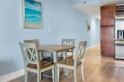 a dining room with a wooden table and chairs at Laketown Wharf #319 by Nautical Properties in Panama City Beach