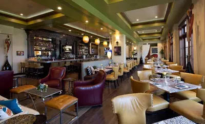 a restaurant with tables and chairs and a bar at The Pearl Hotel in Rosemary Beach