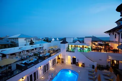 a view of a building with a swimming pool at night at The Pearl Hotel in Rosemary Beach