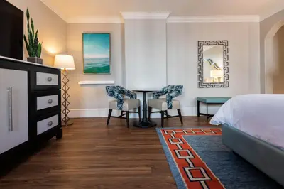 a hotel room with a bed and a desk and chairs at The Pearl Hotel in Rosemary Beach