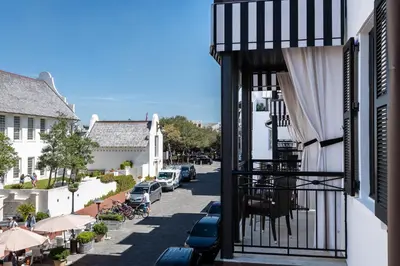 a view from a balcony of a street with parked cars at The Pearl Hotel in Rosemary Beach