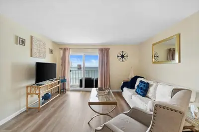 a living room with a couch and a tv at Moonspinner #715A By Book That Condo in Panama City Beach