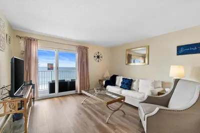 a living room with a white couch and a tv at Moonspinner #715A By Book That Condo in Panama City Beach