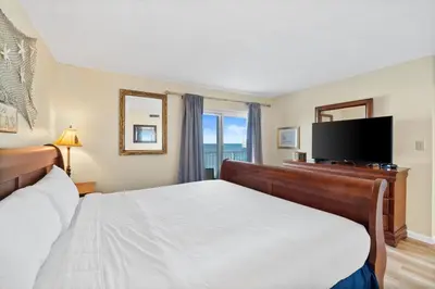 a bedroom with a bed and a flat screen tv at Moonspinner #715A By Book That Condo in Panama City Beach
