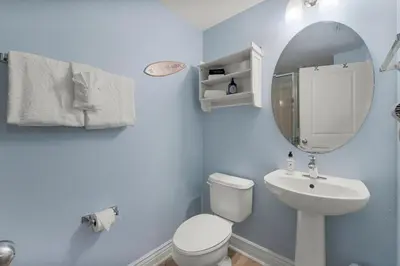 a bathroom with a toilet and a sink and a mirror at Palazzo #505 by InJoy Vacations in Panama City Beach
