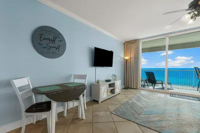 a living room with a dining room table and a television at Palazzo #505 by InJoy Vacations in Panama City Beach