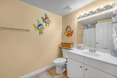 a bathroom with a toilet and a sink and a mirror at Shores of Panama #1230 by Nautical Properties in Panama City Beach