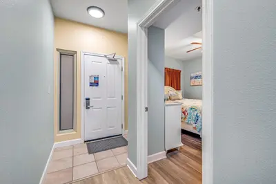 a hallway with a door leading to a bedroom at Shores of Panama #1230 by Nautical Properties in Panama City Beach