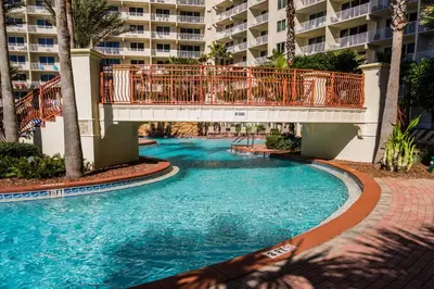 a swimming pool with a bridge in a resort at Shores of Panama #1230 by Nautical Properties in Panama City Beach