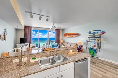 a kitchen with a sink and a view of the ocean at Shores of Panama #1230 by Nautical Properties in Panama City Beach