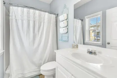 a white bathroom with a toilet and a sink at Coastside 2 BR with 2BA Sleeps 6 Bikes and Pool View in Santa Rosa Beach