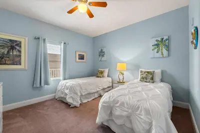 a bedroom with two beds and a ceiling fan at Laketown Wharf #320 by Nautical Properties in Panama City Beach