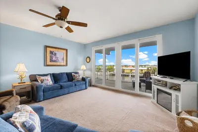 a living room with a blue couch and a flat screen tv at Laketown Wharf #320 by Nautical Properties in Panama City Beach