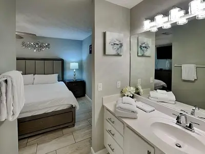 a bedroom with a bed and a sink and a mirror at Horizon South 60-203 in Panama City Beach