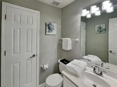 a bathroom with a sink and a toilet and a mirror at Horizon South 60-203 in Panama City Beach