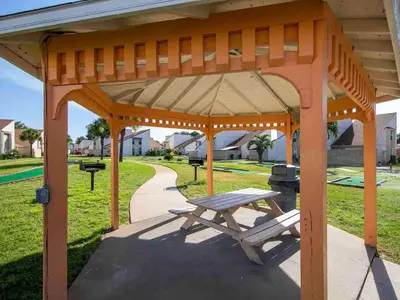 a wooden pavilion with a picnic table in a park at Horizon South 60-203 in Panama City Beach