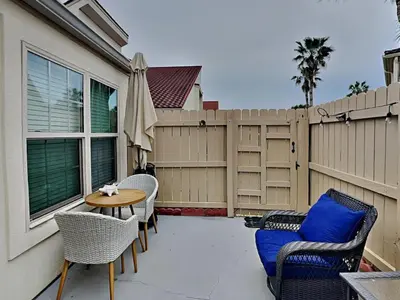 a patio with chairs and a table and a fence at Horizon South 83d in Panama City Beach