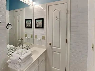 a white bathroom with a sink and a mirror at Horizon South 83d in Panama City Beach