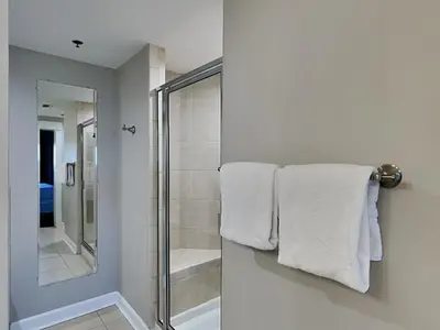 a bathroom with a shower and white towels at Grand Panama Beach Resort - The Grand II #1108 in Panama City Beach