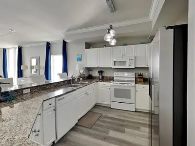 a white kitchen with white cabinets and appliances at Tidewater Beach Resort #1501 in Panama City Beach
