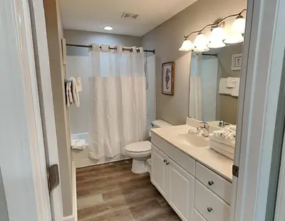 a bathroom with a sink and a toilet and a mirror at Tidewater Beach Resort #1501 in Panama City Beach