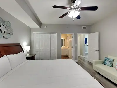 a bedroom with a white bed and a ceiling fan at Tidewater Beach Resort #1501 in Panama City Beach