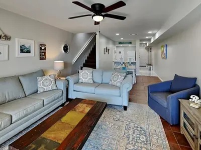 a living room with two couches and a ceiling fan at Edgewater Villa #121 in Panama City Beach