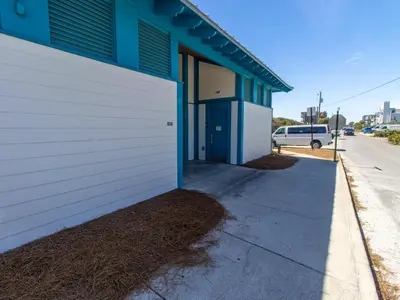 a blue and white building next to a sidewalk at Inlet Dunes #102 in Inlet Beach