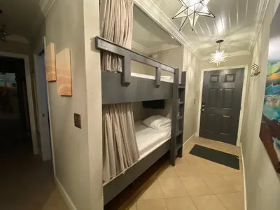 a bunk bed in a room with a door at Inlet Dunes #102 in Inlet Beach