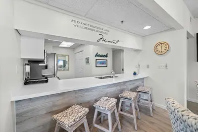 a waiting room with three stools and a counter at HP 325 Sandy Bottoms by 30A Escapes in Rosemary Beach