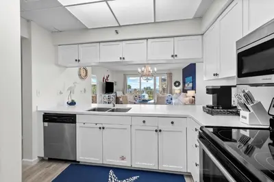a kitchen with white cabinets and a sink at HP 325 Sandy Bottoms by 30A Escapes in Rosemary Beach