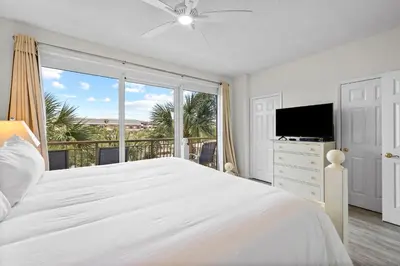 a bedroom with a white bed and a large window at HP 325 Sandy Bottoms by 30A Escapes in Rosemary Beach