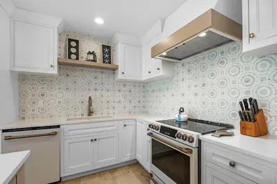 a kitchen with white cabinets and a stove top oven at The Legacy Unit 203 in Seagrove Beach