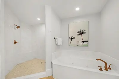 a white bathroom with a tub and a sink at The Legacy Unit 203 in Seagrove Beach