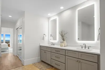 a white bathroom with two sinks and a mirror at The Legacy Unit 203 in Seagrove Beach