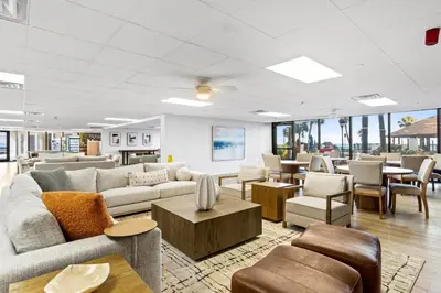 a living room with couches and tables and chairs at Summerhouse Beach Resort by Panhandle Getaways in Panama City Beach