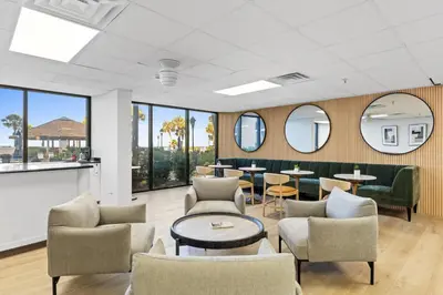 a waiting room with chairs and tables and windows at Summerhouse Beach Resort by Panhandle Getaways in Panama City Beach