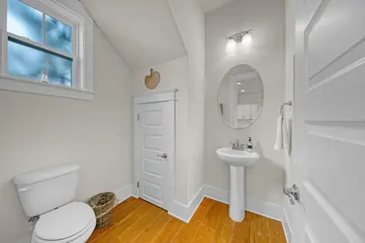 a white bathroom with a toilet and a sink at Free Golf Cart, 5 min to Beach, Community Pool in Inlet Beach