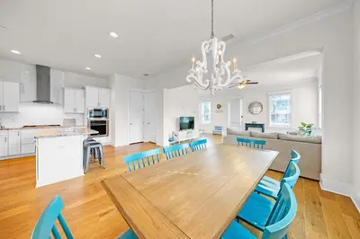 a kitchen and living room with a wooden table and chairs at Free Golf Cart, 5 min to Beach, Community Pool in Inlet Beach