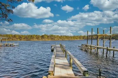 a dock on a lake with clouds in the sky at Free Golf Cart, 5 min to Beach, Community Pool in Inlet Beach