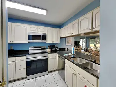 a kitchen with white cabinets and a sink at Edgewater Villa #1607 in Panama City Beach