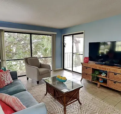 a living room with a couch and a tv at Edgewater Villa #1607 in Panama City Beach