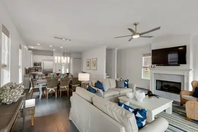 a living room with white furniture and a fireplace at Beach House with Heated Pool 100 Steps from Beach in Panama City Beach