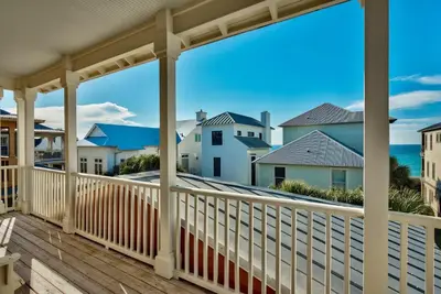a balcony with a view of houses and the ocean at Beach House with Heated Pool 100 Steps from Beach in Panama City Beach