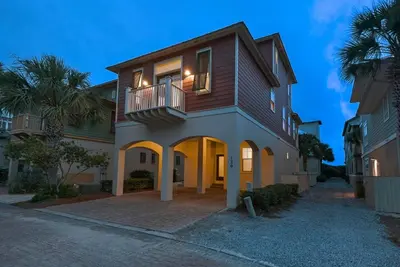 a house with a balcony on the side of it at Beach House with Heated Pool 100 Steps from Beach in Panama City Beach